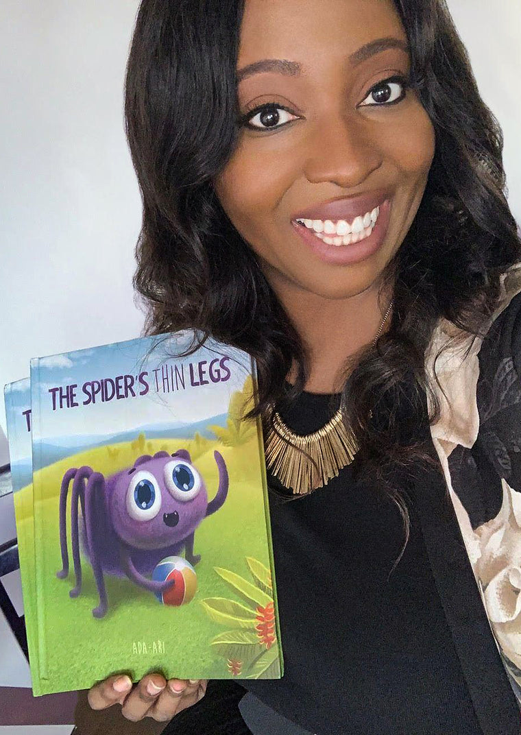 Ada Ari holding one of her books